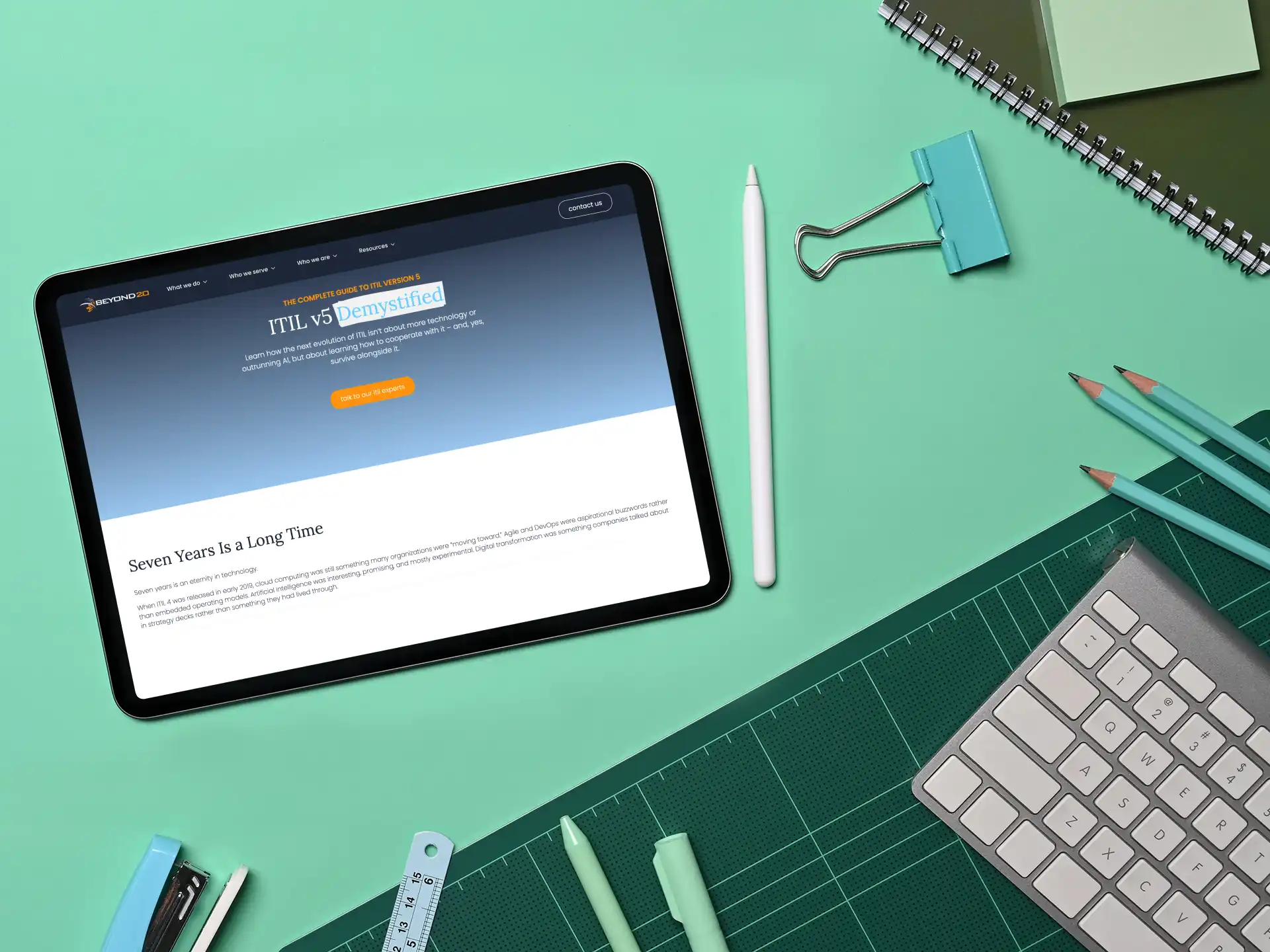 ipad on green desk with itil 5 complete guide on screen
