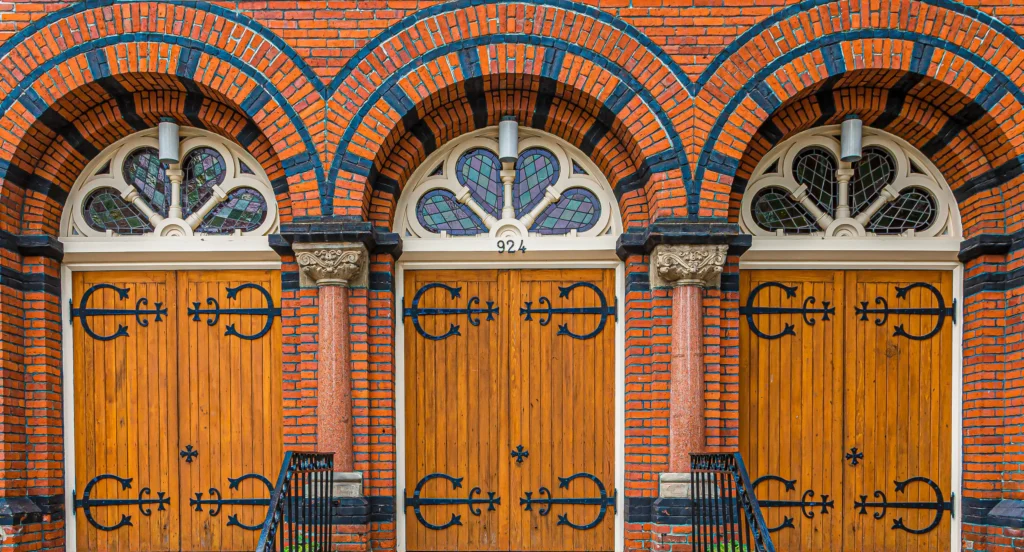 three fancy wooden doors on a church